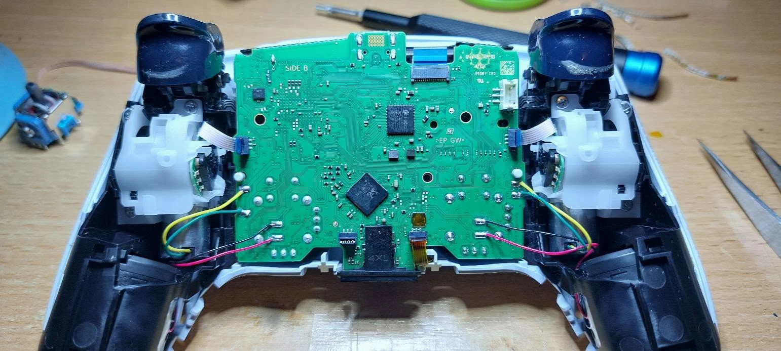 Interiorul controllerului DualSense, cu placa electronică și conexiunile sale
