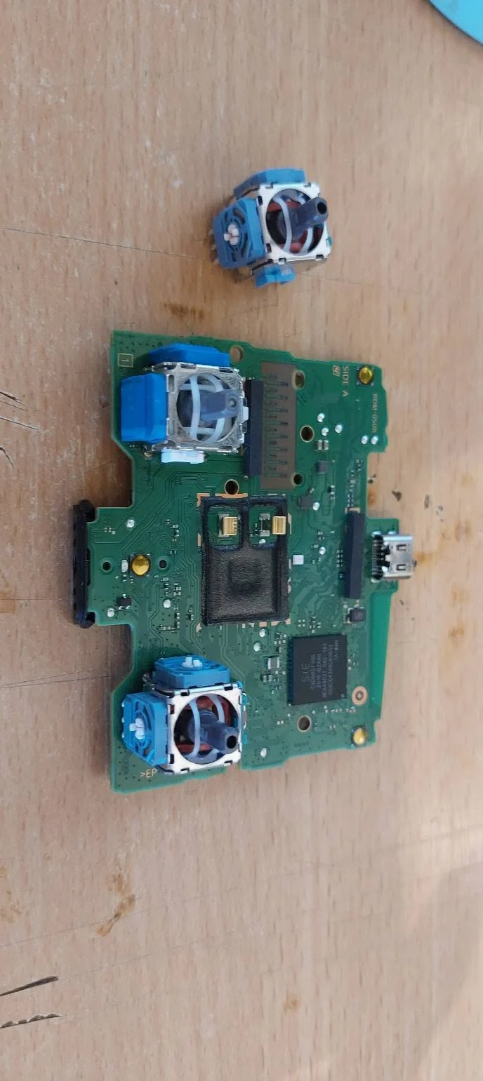 Placa electronică a manetei DualSense și modulele analogice, văzute de sus
