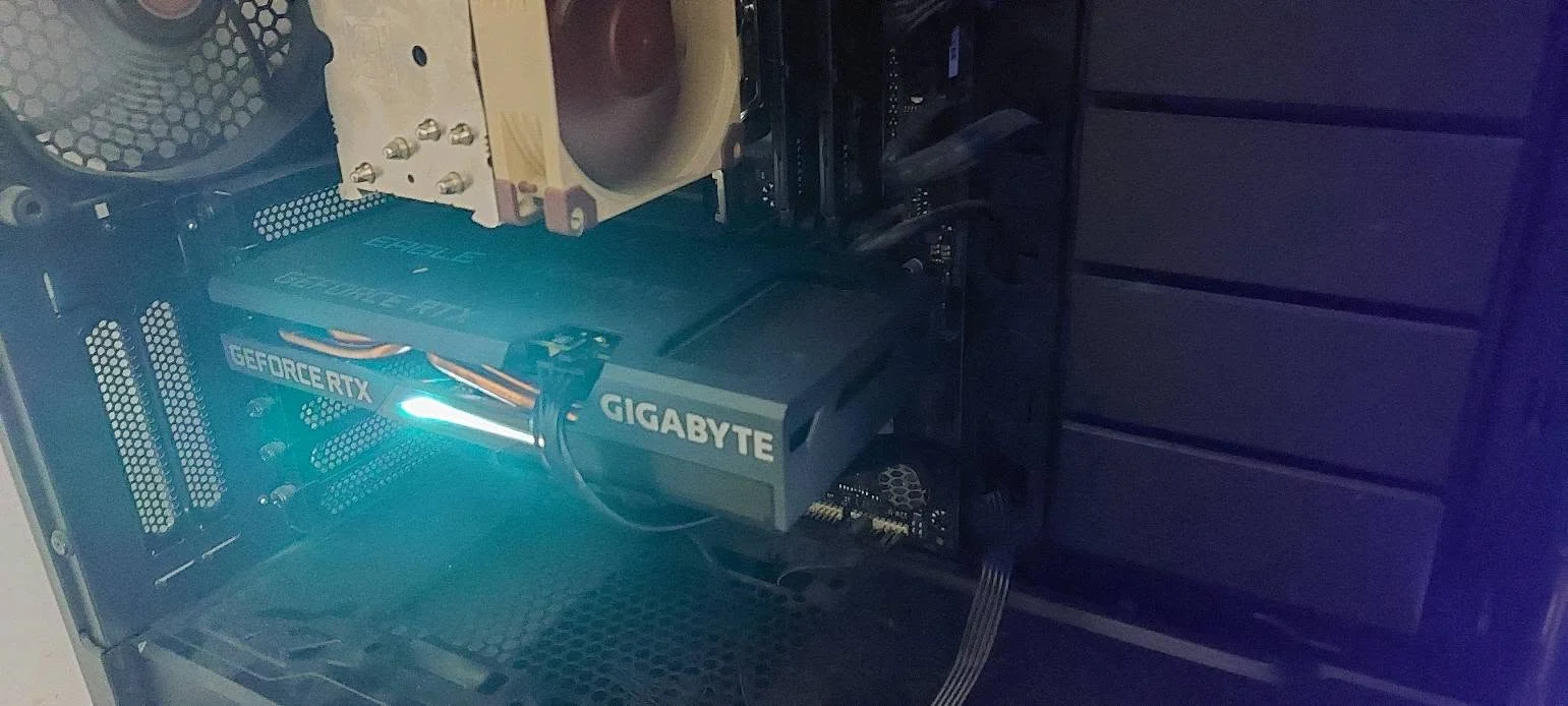 Placa video Gigabyte RTX 3060 Ti montată în calculator, cu iluminarea activă