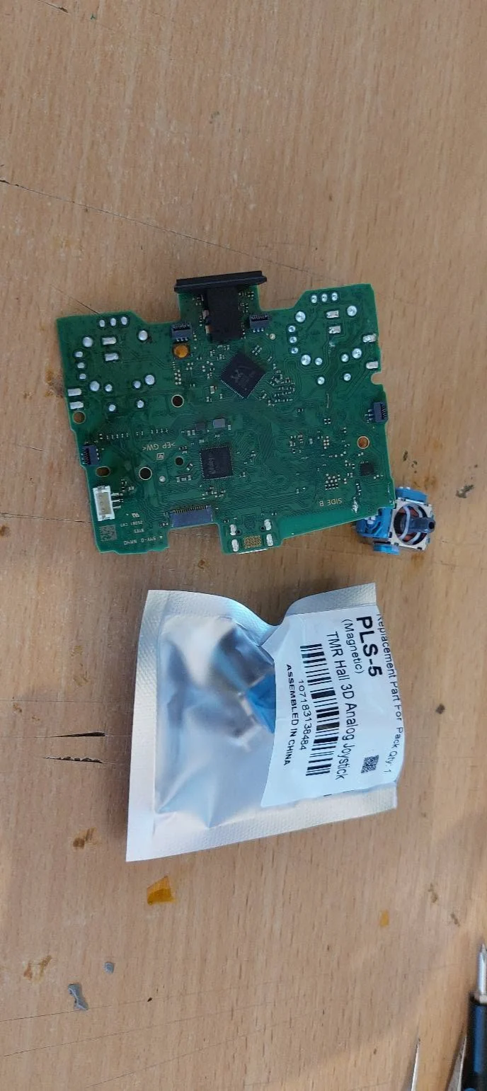 Placa electronică DualSense alături de un modul analogic ambalat